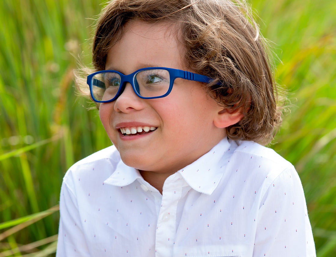 Cyrus, smiling and wearing a white shirt and blue glasses